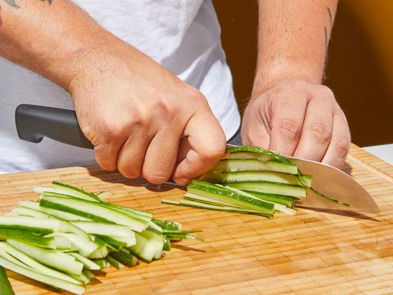 Quarter the cucumber lengthwise, remove the seeds and slice into thin sticks. Finely mice the remaining lemongrass. Now add hoisin sauce, peanut butter, remaining garlic, water, lemon juice, sesame oil and sugar into a food processor and blend until smooth.